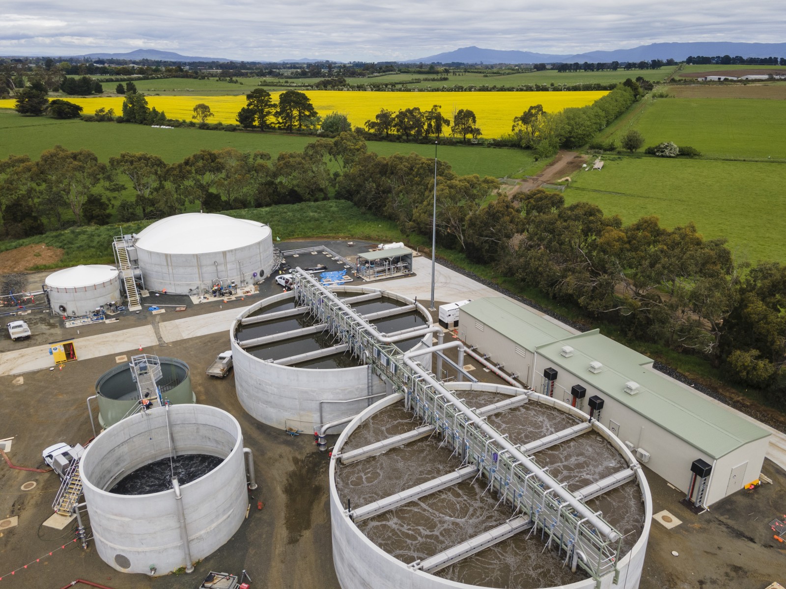 Aerial view of the Longford sewage treatment plant, with circular tanks and buildings beside farmland