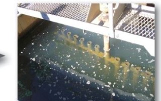 Floc particles forming in a flocculation tank beneath a steel grating walkway