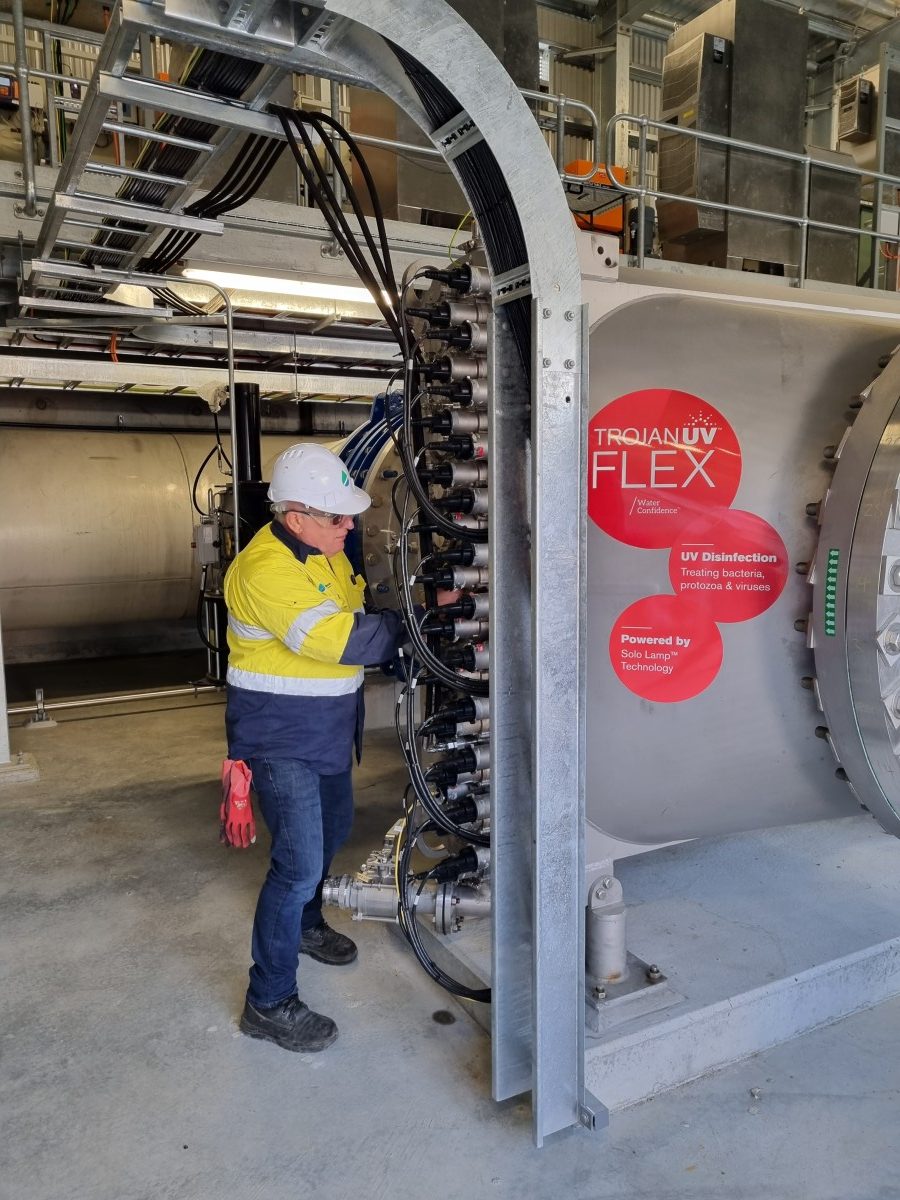 Technician in hi-vis working on lamp connections while commissioning a Trojan UV Flex reactor